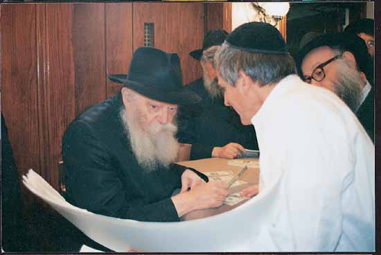 The Rebbe writing a reply while a visitor stands before him