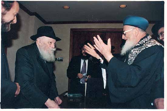 The Rebbe receiving a guest who raises his hands in blessing